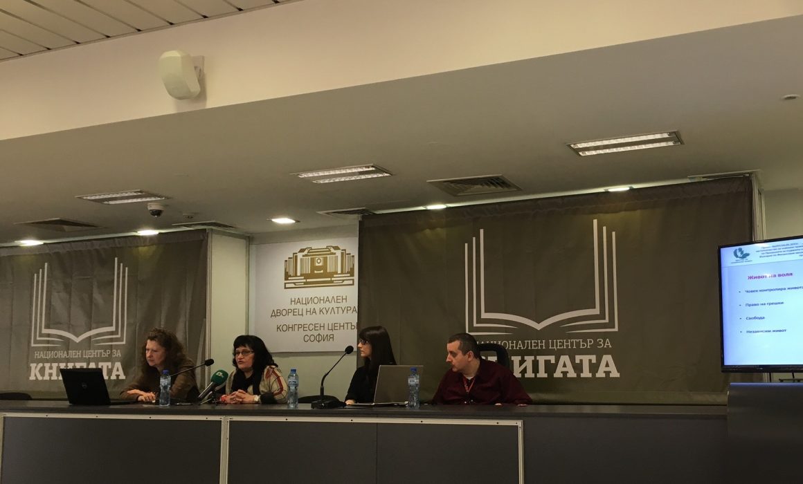 хора седящи на подиум в конферентна зала